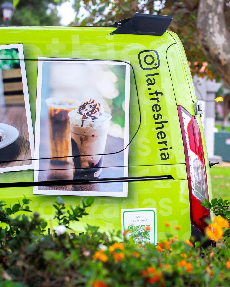 Lime green La Fresheria food truck with images of iced coffee and a QR code.
